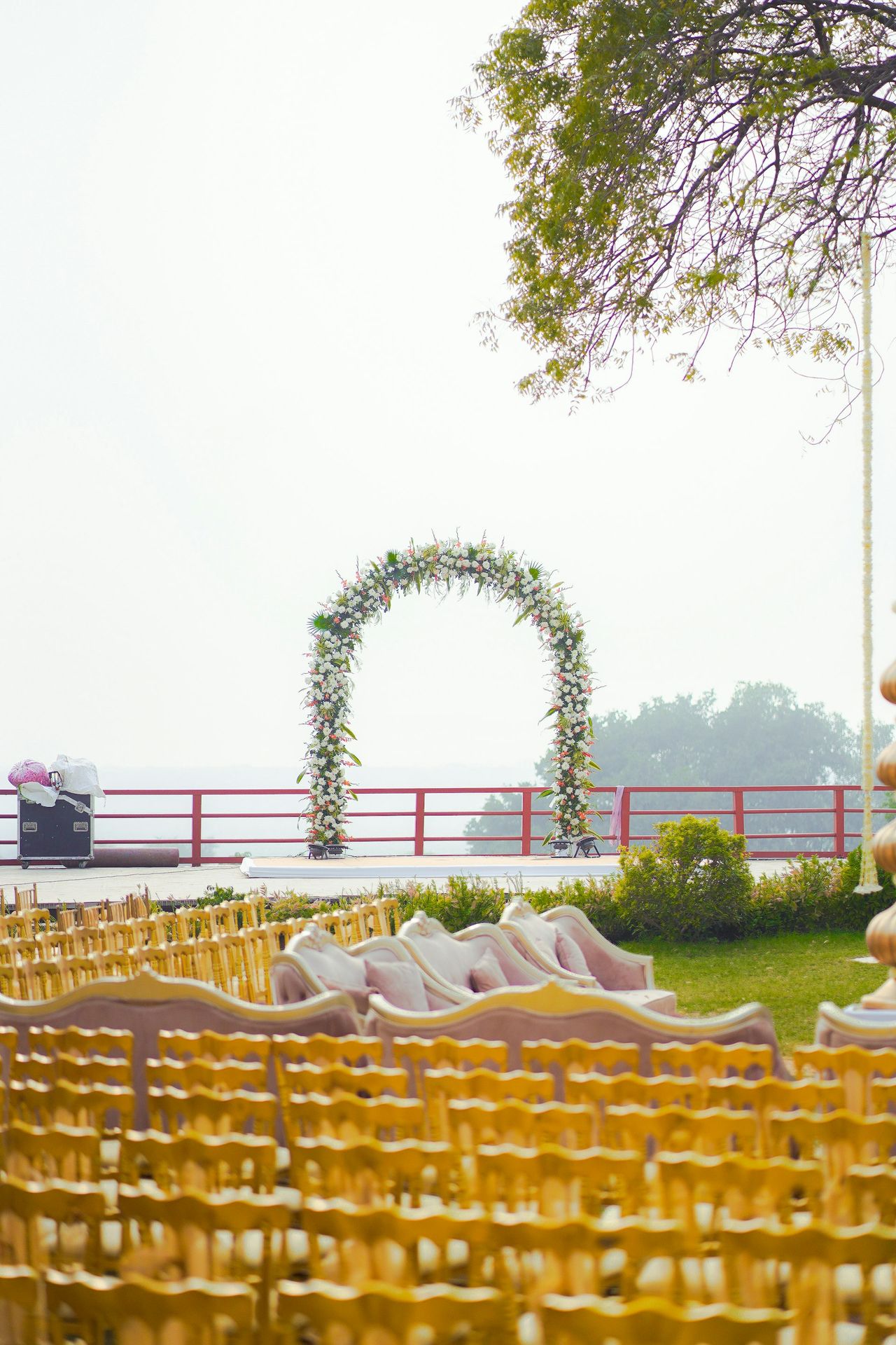 A wedding ceremony setup with floral arch and seating